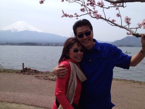 Carol and Ray Chow under cherry blossom with Mt. Fuji in the background.