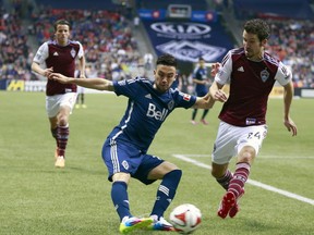 VANCOUVER, BC - APRIL 5:  Pedro Morales #77 of the Vancouver Whitecaps FC plays the ball in front of Nathan Sturgis #24 of the Colorado Rapids during their MLS game April 5, 2014 in Vancouver, British Columbia, Canada. (Photo by Jeff Vinnick/Getty Images) ORG XMIT: 462857505