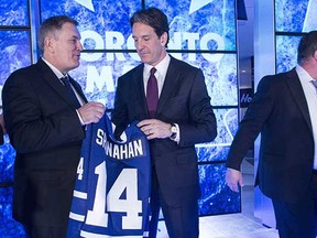 New Toronto Maple Leafs president Brendan Shanahan gets a jersey (and some advice?) from Maple Leafs Sports and Entertainment CEO Tim Leiweke (left) while general manager Dave Nonis (right) heads out of the picture during this week's news conference announcing Shanahan's appointment.