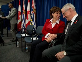 British Columbia Premier Christy Clark, centre, and Dr. Julio Montaner, right, director for the B.C. Centre for Excellence in HIV/AIDS, talk as UNAIDS executive director Michel Sidibe, left, speaks after Clark announced the dedicated AIDS ward at St. Paul's Hospital would no longer just treat patients with HIV/AIDS because of a lack of demand due to the success of the centre, in Vancouver, B.C., on Tuesday May 27, 2014.