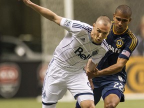 APRIL 19 2014. Vancouver Whitecaps Kenny Miller battles Los Angeles Galaxy Leonardo in MLS action Saturday at BC Place  in Vancouver, B.C., on April 19, 2014.  (Steve Bosch  /  PNG staff photo)       [PNG Merlin Archive]
