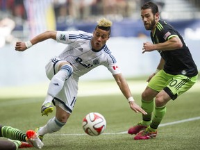 Erik Hurtado moves on the ball, watched by Seattle Sounders' Zach Scott in a 2-2 draw at BC Place