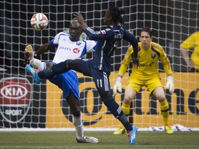 Montreal Impact' Hassoun Camara, left, defends against Vancouver Whitecaps' Darren Mattocks, centre, in front of goalkeeper Troy Perkins during first half MLS soccer action in Vancouver, B.C., on Wednesday.
THE CANADIAN PRESS/Darryl Dyck