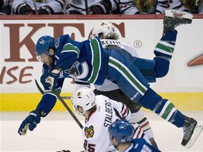 Chicago Blackhawks left wing Viktor Stalberg (25) looks on as Vancouver Canucks center Ryan Kesler (17) flies over Chicago Blackhawks defenseman Duncan Keith (2) during third period NHL hockey action at Rogers Arena in Vancouver, British Columbia, Monday, April 22, 2013. (AP Photo/The Canadian Press, Jonathan Hayward)