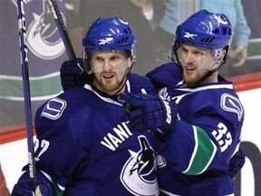 Vancouver Canucks' Daniel Sedin, left, and Henrik Sedin, both of Sweden, celebrate Henrik's goal against the Chicago Blackhawks during the third period of an NHL hockey game in Vancouver, British Columbia, Canada, on Saturday, Jan. 23, 2010. (AP Photo/The Canadian Press, Darryl Dyck)