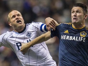 Vancouver Whitecaps captain Jay Demerit (left) jousts with the L.A. Galaxy’s Robbie Keane during a Major League Soccer game last April at BC Place Stadium. (Steve Bosch, PNG)
