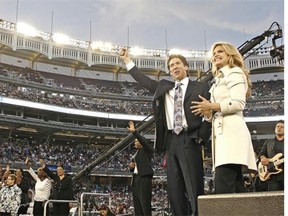 While tens of millions of people seeking success and wealth put their faith in televangelist Joel Osteen, critics charge his message has little to do with Jesus, who taught, “You cannot serve both God and mammon.” (Photo: Joel Osteen and Victoria at Yankee Stadium.)