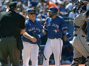 Toronto Blue Jays manager John Gibbons tries to calm down slugging star Jose Bautista (centre right) after the latter was ejected by home plate umpire Bill Welke for arguing a called third strike during Sunday's 2-1, 10-inning loss to the Tampa Bay Rays at the Rogers Centre in Toronto. (Tom Szczerbowski, Getty Images)