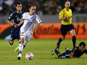 Landon Donovan of the L.A. Galaxy drives past a sprawling Steven Beitashour of the Vancouver Whitecaps during their Aug. 23, 2014 MLS game at StubHub Center in Carson, Calif. (Jeff Gross, Getty Images)