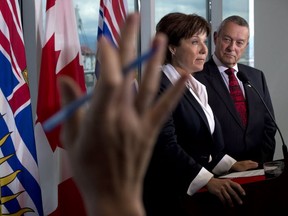 A reporter tries to ask a question as British Columbia Premier Christy Clark and Education Minister Peter Fassbender talk about the ongoing teachers' dispute at a news conference in Vancouver, Wednesday.
