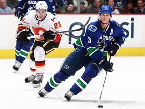Kevin Bieksa (right) will be in Calgary Wednesday, but it’s a game-time decision on whether he will take to the ice against Sean Monahan (left) and the Flames. (Jeff Vinnick, NHLI via Getty Images files)