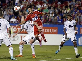 FC Dallas midfielder Mauro Diaz (in red) jumps into Vancouver Whitecaps centre back Andy O’Brien while Jordan Harvey and Ethen Sampson (right) watch during Wednesday’s MLS playoff game in Frisco, Texas. (Tony Gutierrez, Associated Press)