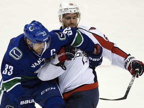 Vancouver Canucks captain Henrik Sedin (left) ties up Washington Capitals defenceman Mike Green during the second period of their NHL game at Rogers Arena on Sunday, Oct. 26, 2014. (Darryl Dyck, Canadian Press)