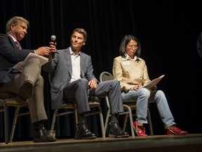 Non-Partisan Association mayoral candidate Kirk LaPointe passes the mic to Vancouver Mayor Gregor Robertson as COPE mayoral candidate Meena Wong looks at her notes during the Metro Vancouver Alliance Municipal Accountability Assembly panel discussion held at the Italian Cultural Centre in Vancouver, BC, October, 9, 2014.