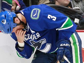 Kevin Bieksa of the Vancouver Canucks grabs his face after he was struck in the right eye by a deflected puck during Sunday's NHL game against the Nashville Predators at Rogers Arena. (Jeff Vinnick, NHLI via Getty Images)