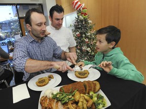 Chef Waldemar Bilski (left) with chef Steven Hodge (centre) and Jake Hunter-Wee, 9, dig into leftovers at Hodge's Temper cafe in West Vancouver