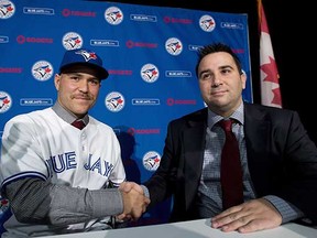 Key Toronto Blue Jays free-agent acquisition Russell Martin (left) seals the deal with Jays GM Alex Anthopoulos last November. Martin's salary for next year is a mere $7 million. (Nathan Denette, Canadian Press files)