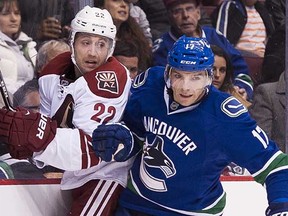 Arizona Coyotes’ Brandon McMillan (left) gets squeezed out along the boards by Vancouver Canuck Radim Vrbata during a Nov. 14, 2014 NHL game at Rogers Arena. McMillan was picked up on waivers by the Canucks on Thursday. (Richard Lam, PNG)