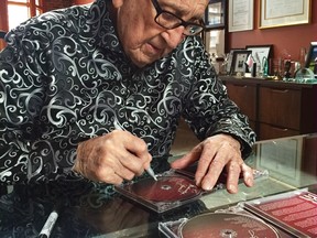 Vancouver music legend Dal Richards autographs one of his CDs for a newspaper reporter after an interview in his home.