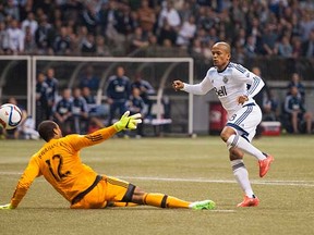 Robert Earnshaw of the Vancouver Whitecaps scores the game-winning goal past Portland Timbers goalkeeper Adam Kwarasey in their MLS game on Saturday at BC Place Stadium in Vancouver. (Rich Lam, Getty Images)
