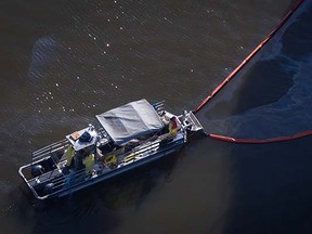 A spill response boat monitors a boom placed around the bulk carrier cargo ship Marathassa after a bunker fuel spill on Burrard Inlet in Vancouver, B.C., on Thursday April 9, 2015. THE CANADIAN PRESS/Darryl Dyck