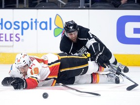 Jake Muzzin #6 of the Los Angeles Kings and David Jones #19 of the Calgary Flames fall to the ice while chasing the puck during the first period at Staples Center on January 19, 2015 in Los Angeles, California.  (Photo by Harry How/Getty Images)