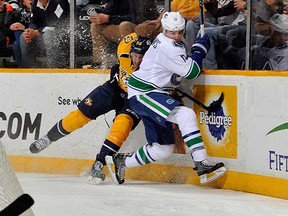 Vancouver Canucks winger Alex Burrows rubs out Nashville Predator Roman Josi along the boards during Tuesday’s NHL game at Bridgestone Arena in Nashville, Tenn. (Frederick Breedon, Getty Images)