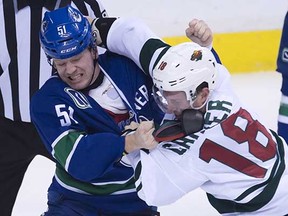 Vancouver Canucks winger Derek Dorsett (left) trades shots with the Minnesota Wild’s Ryan Carter during a February NHL game at Rogers Arena. (Jonathan Hayward, Canadian Press)