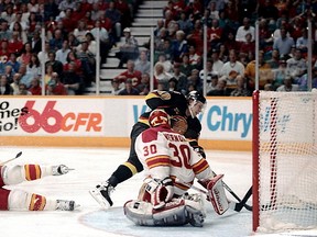 Pavel Bure slips the puck past Flames goalie Mike Vernon in double overtime in the seventh and deciding game of the 1994 Western Conference quarter-final at the Saddledome. Dean Bicknell/Calgary Herald.