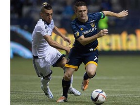 Vancouver Whitecaps midfielder Russell Teibert (left) hounds L.A. Galaxy striker Robbie Keane during Saturday’s 2-0 shutout win over the Galaxy at BC Place Stadium. (Darryl Dyck, Canadian Press)