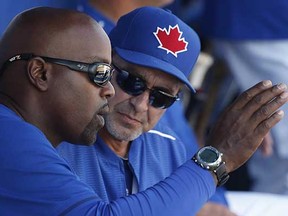 Toronto Blue Jays guest instructor Carlos Delgado (left) gestures as he talks to Blue Jays hitting coach Brook Jacoby in the dugout during a spring training game in March. The Major League Baseball umpires' union says the 14-game suspension imposed on Toronto hitting coach Jacoby shows there is a ‘clear line’ that cannot be crossed. (Kathy Willens, Canadian Press)