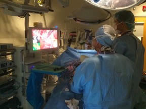 Dr. Neely Panton (left) and Dr. Geoff Chow do a laparoscopic gallbladder removal operation at UBC Hospital, using the new Pinpoint Endoscopic Fluorescence Imaging system eveloped by a Canadian company called Novadaq.