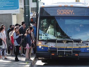 Commuters line up at Joyce-Collingwood sky train station for temporary bus service after an overnight  fire closed the line between Joyce and Waterfront Station,  in Vancouver, BC., May 22, 2015.  (Nick Procaylo/PNG)