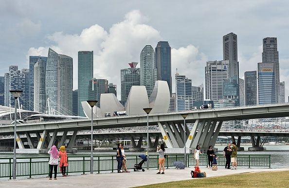 People enjoy the view of the city skyline along Marina Bay in Singapore on March 3, 2015.    AFP PHOTO / ROSLAN RAHMAN        (Photo credit should read ROSLAN RAHMAN/AFP/Getty Images)