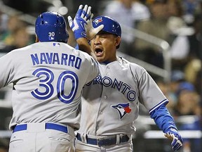 Toronto Blue Jays pinch runner Ezequiel Carrera celebrates with teammate Dioner Navarro after scoring on Navarro's 11th-inning sacrifice fly against the New York Mets in New York on Monday. (Kathy Willens, Associated Press)