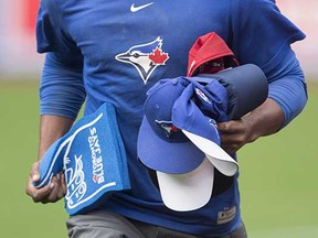 A member of the Toronto Blue Jays' grounds crew collects hats thrown on the field following Edwin Encarnacion's third home run during the seventh inning of their 15-1 win over the Detroit Tigers on Saturday. (Darren Calabrese, Canadian Press)
