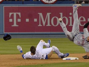 New York Mets shortstop Ruben Tejada falls after a slide by the Los Angeles Dodgers' Chase Utley (left) during the seventh inning of their National League Divisional Series game on Saturday. (John McCoy, Los Angeles Daily News via AP)