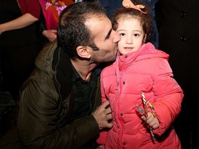 Ashour Esho greets his cousin’s little girl, Syrian refugee Maysa Yousef, 3, at the Calgary International Airport on Nov. 23, 2015.