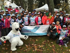 The Great Climate Race founder Ben West, kneeling in the front row on the right, poses for photos with the Latin Runners and the polar bear mascot before the start of Sunday morning's inaugural event at Stanley Park.