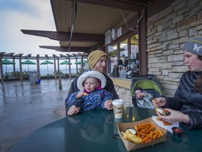 Benjamin and Stephanie Grant with kids Molly 3 and Noah 1 eat outside the Beach Cafe at Spanish Banks East on N.W. Marine Dr. in Vancouver, BC. December 22, 2015. Ruben Chapiel and his daughter Allice have run the Spanish Banks East concession for 5 years. They're one of the few concessions open in winter in Vancouver. The city says the stand they operate out of was built in 1950 - one of the five oldest concession buildings in the parks system.
