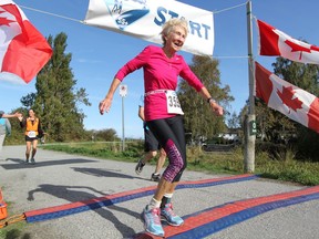 Gwen McFarlan, 81, crosses the finish line during the inaugural Forever Young 8K in September in Richmond. McFarlan, a co-founder of the inspirational seniors club, holds a women's world marathon record for runners in her age class.