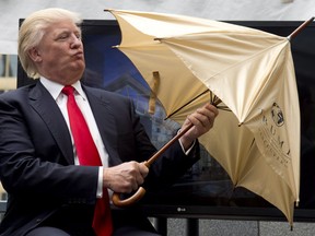Donald Trump opens a ceremonial umbrella given to him during an announcement in downtown Vancouver, B.C. Wednesday, June 19, 2013. The Trumps were on Canada's west coast to announce the building of Trump International Hotel and Tower Vancouver. THE CANADIAN PRESS/Jonathan Hayward