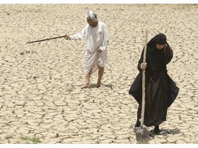 Adilla Finchaan, 50, and her husband, Ashore Mohammed, 60 walk their dried-up farmland in Iraq in this 2009 photograph. The Tigris-Euphrates region has suffered consecutive years of drought. 
 Credit: AP