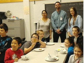 Adults from left to right, Raj Gill, Kyle Tye, Beige Osland are all volunteering at Hyland Elementary school in Surrey, serving breakfast to children. Tye and Osland both work for Westland Insurance Group, which gives employees time time off with pay to volunteer at the school.