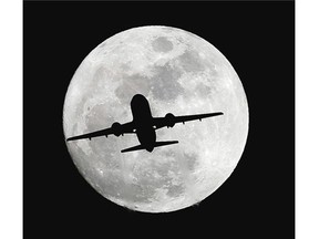 An airplane crosses a nearly full-moon on its way to Los Angeles International Airport near Whittier, Calif., Thursday, Dec. 24, 2015. Not since 1977 has a full moon dawned in the skies on Christmas.