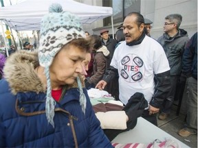 Alex Watts (in white) and a team of 50 volunteers hand out items to the needy on Main Street at Hastings Street in Vancouver on Friday.