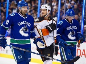 Anaheim Ducks #2 Kevin Bieksa is sandwiched between Vancouver Canucks #20 Chris Higgins and#7 Linden Vey during a break in play in the first period of a regular season NHL hockey game at Rogers Arena, Vancouver January 01 2016.