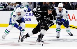 Los Angeles Kings left wing Milan Lucic (17) starts on a break awa, as Vancouver Canucks left wing Alex Burrows (14) and defenseman Dan Hamhuis (2) give chase during the second period of an NHL hockey game in Los Angeles, Tuesday, Oct. 13, 2015.