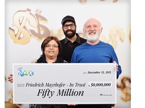 Annand Mayrhofer, Eric Mayrhofer and Friedrich Mayrhofer pose with their $50-million winning lottery cheque in Vancouver, Tuesday, Dec.15, 2015.