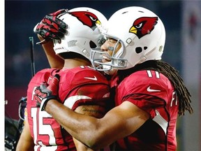 Arizona Cardinals wide receiver Michael Floyd (15) celebrates his touchdown catch with teammate  Larry Fitzgerald (11) during the first half of an NFL divisional playoff football game against the Green Bay Packers, Saturday, Jan. 16, 2016, in Glendale, Ariz.